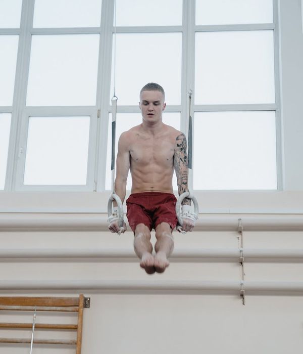 Man performing balanced strength exercises in a modern gym setting